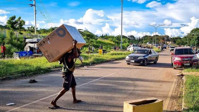 An apparent thief returns home with goods looted during the riots. Picture: Facebook