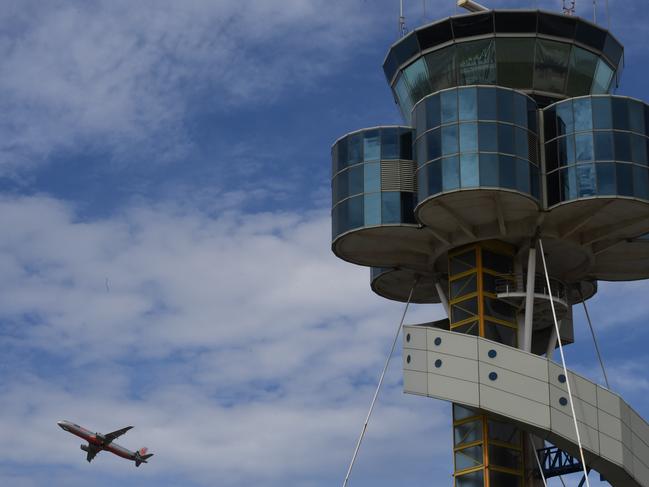 The control tower at Sydney Airport is seen as a plane takes off in Sydney, Friday, March 29, 2019. Flights are slowly resuming after Sydney Airport's air traffic control tower was evacuated after smoke was detected inside. (AAP Image/Peter Rae) NO ARCHIVING