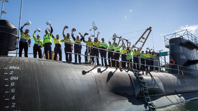 Workers standing on HMAS Farncomb, docked at ASC's Osborne shipyard.