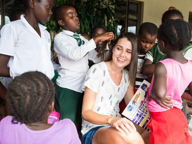 Heather Maltman gets her hair done by one of the children at the orphanage. Picture: Benjamin Stavert