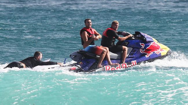 t Joel Parkinson and Mick Fanning give friends a tow back to the line up. Picture Glenn Hampson