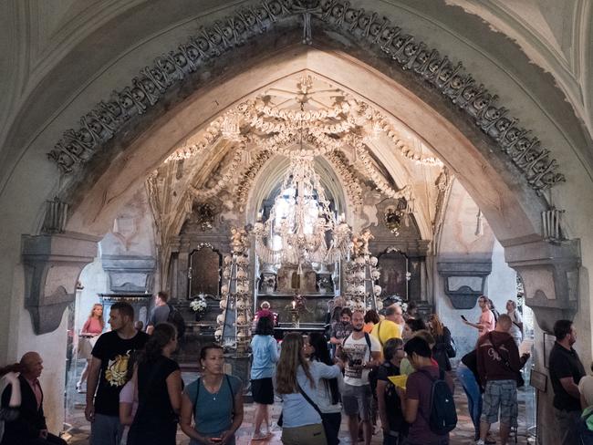 Kutna Hora, Czech Republic - 19 August 2017: Tourists visit the Sedlec Ossuary (Kostnice Sedlec) small Gothic chapel decorated with human bones.