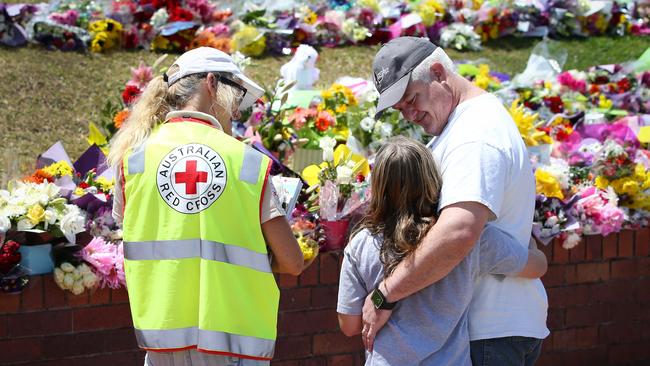 Mourners visit the tribute to those who lost their life on the Thunder River Rapids ride at Dreamworld. Picture: NIGEL HALLETT