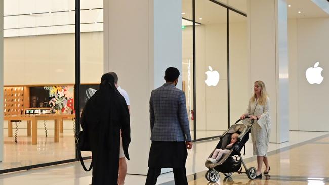 People walk past the Apple store at a Mall in Dubai after the company revealed plansn to close all stores outside China due to COVID-19. Picture: GIUSEPPE CACACE / AFP