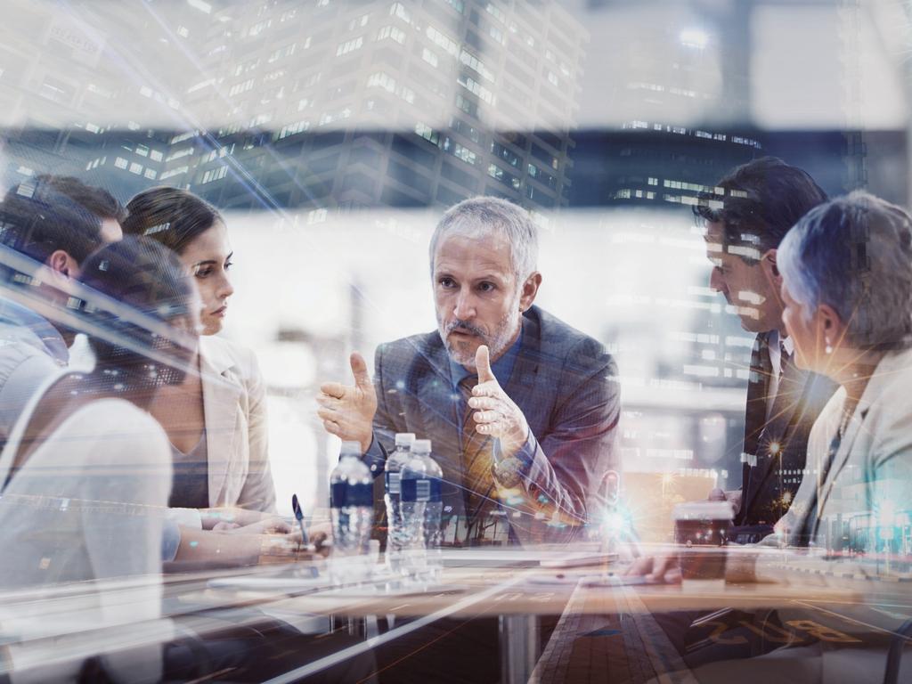 Multiple exposure shot of a group of businesspeople brainstorming together superimposed on a city at night. Istock