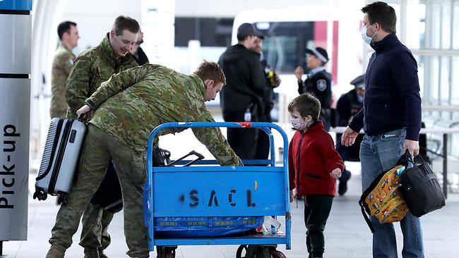 Arriving international passenger are helped onto buses at Sydney airport by ADF, police and airport security. Picture: Jane Dempster