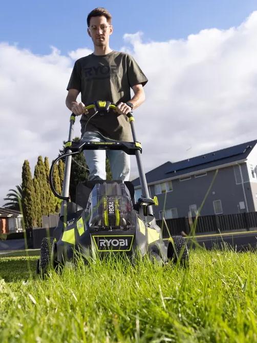 A Ryobi electric mower in action.