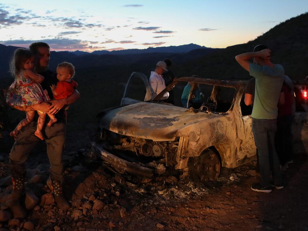 Devastated relatives view one of the burnt-out cars at the scene of Monday’s deadly ambush. Picture: Herika Martinez? AFP