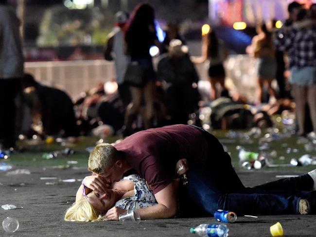 A man lays on top of a woman as others flee the Route 91 Harvest country music festival grounds after an active shooter was reported. Picture: David Becker/Getty Images/AFP