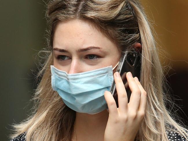 SYDNEY, AUSTRALIA - DECEMBER 24: A shopper walks in Sydney's CBD on December 24, 2021 in Sydney, Australia. New COVID-19 rules have come into effect as of midnight, with masks required in indoor settings. The new rules have been introduced in an effort to slow the spread of the Omicron variant, following a surge of new COVID-19 cases across the state. From Monday 27 December, QR code check ins will once again be compulsory, including for hospitality and retail, while hospitality venues, including pubs, clubs, restaurants and cafes will move to 1 person per 2 sqm rule indoors, with no density limit for outdoor settings. (Photo by Jason McCawley/Getty Images)