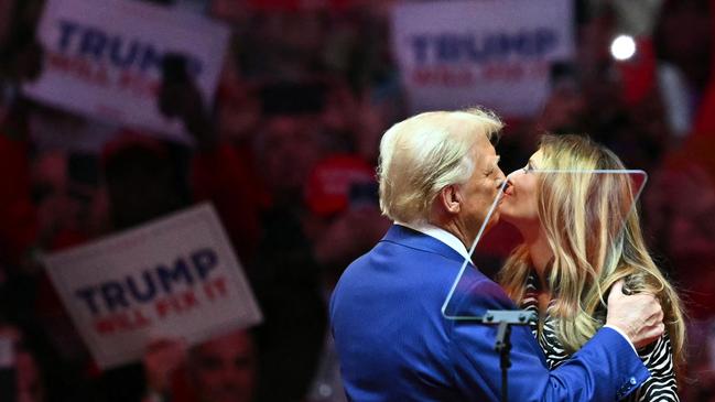 Former US President and Republican presidential candidate Donald Trump kisses former First Lady Melania Trump on stage during a campaign at Madison Square Garden in New York, October 27, 2024. (Photo by ANGELA WEISS / AFP)