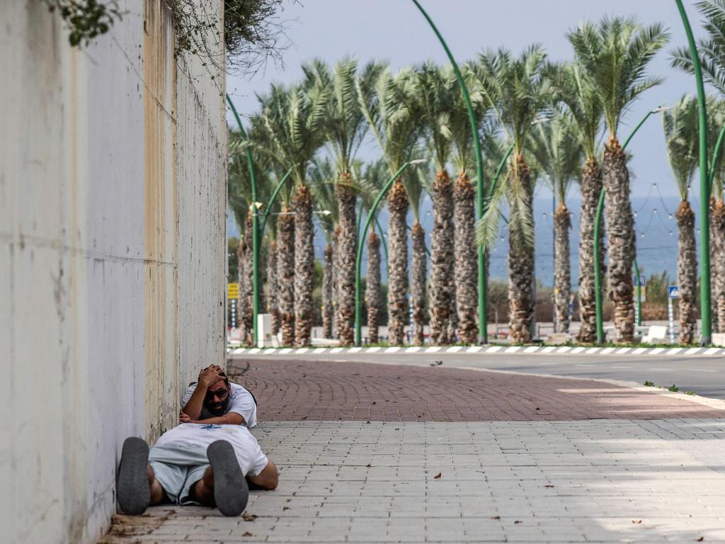 People duck for cover upon hearing sirens warning of incoming fire in the southern Israeli city of Ashkelon. Picture: AFP