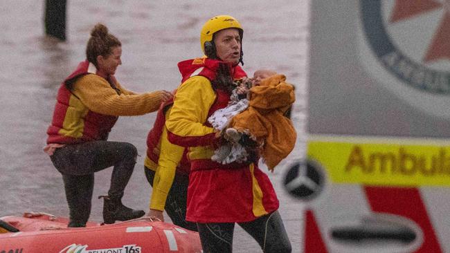 The baby let out a big cry once it was safe onshore in the arms of a life saver awaiting an ambulance. Picture: Liam Mendes / The Australian