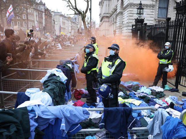 Activists throw NHS uniforms at police officers outside Downing Street as protesters are demanding a stop to Covid vaccines for children and vaccine mandates. Picture: Getty Images