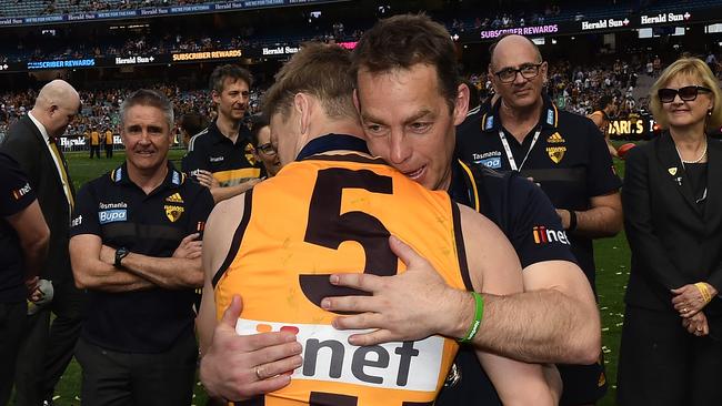 Alastair Clarkson and Sam Mitchell embrace after winning the 2015 AFL Premiership. On Saturday the pair will face off as Clarkson clashes with his former side for the first time as coach of North Melbourne (AAP Image/Julian Smith)