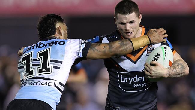 SYDNEY, AUSTRALIA - JULY 12:  John Bateman of the Wests Tigers is tackled during the round 19 NRL match between Cronulla Sharks and Wests Tigers at PointsBet Stadium on July 12, 2024, in Sydney, Australia. (Photo by Brendon Thorne/Getty Images)