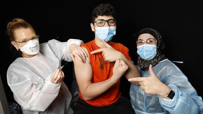 Meg Parsons gives the jab to Ali Fahour, 16, as his aunt Wafa Fahour watches on. Picture: Alex Coppel