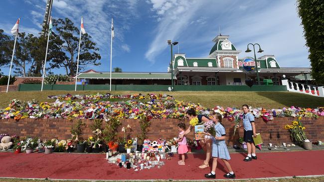 Children lay flowers at a makeshift memorial outside Dreamworld in the days after the Thunder River Rapids ride tragedy. Picture: AAP Image