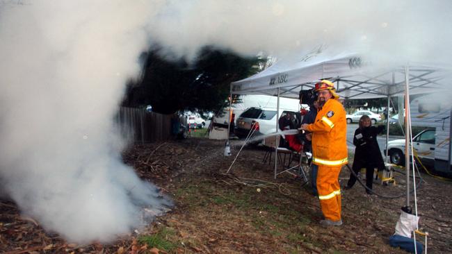 The Beaconsfield fire brigade putting out a camp fire behind the media tents which caused smoke to drift on to the <i>Sunrise</i> set.