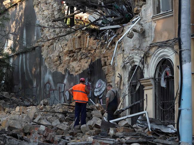 Two men stand among the rubble of a building damaged as a result of a missile strike in Odesa on July 23, 2023. At least one person was killed and more than 15 wounded in a Russian attack on the southern Ukrainian port city of Odesa, the governor of the region said. (Photo by Oleksandr GIMANOV / AFP)