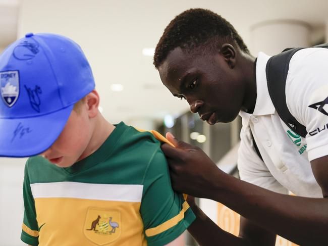 SYDNEY, AUSTRALIA - DECEMBER 05: Garang Kuol of the Socceroos signs autographs on arrival at Sydney International Airport on December 05, 2022 in Sydney, Australia. (Photo by Mark Evans/Getty Images)