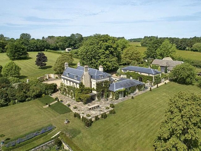 The stately home is surrounded by rolling hills and lush greenery.