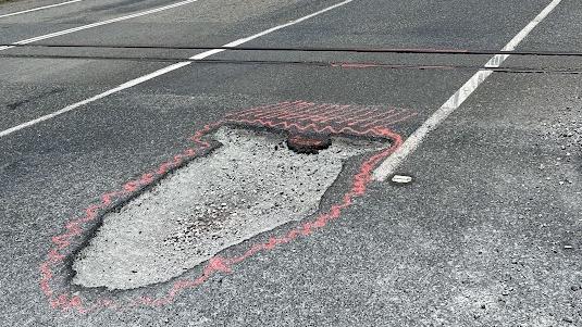 Motorists are having to swerve over solid white lines to avoid a massive pothole near Koumala south of Mackay along the Bruce Highway. Picture: Mitchell Dyer