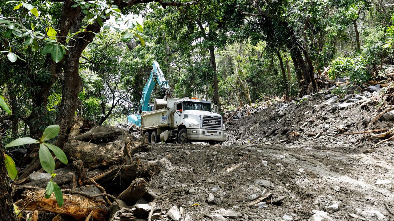 An excavator clears debris from a huge landslide covering the Captain Cook Highway at Ellis Beach. Debris including mud, rocks and tree vegetation completely cut the Captain Cook Highway after flooding caused by ex Tropical Cyclone Jasper created devastation across the Cairns region. Picture: Brendan Radke