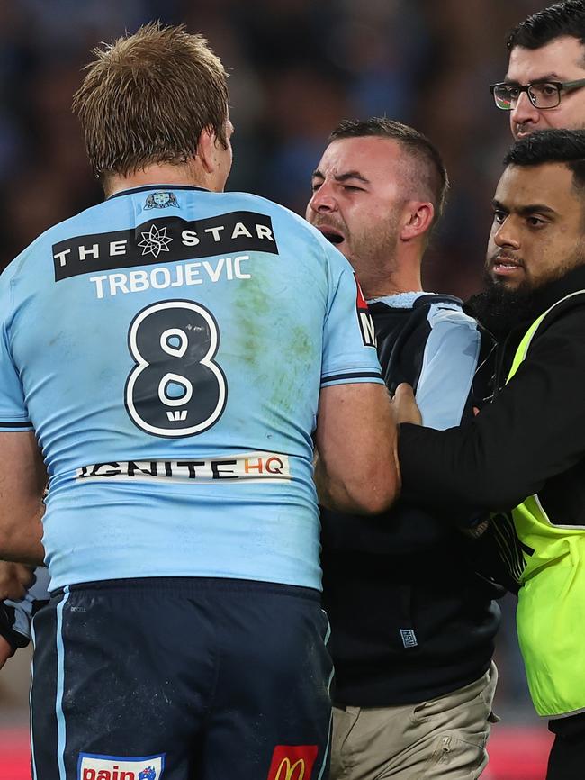 A pitch invader confronts Jake Trbojevic. Picture: Mark Kolbe/Getty