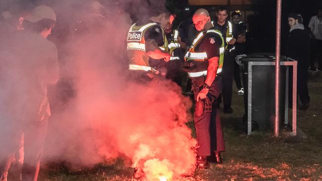 Police stand over a flare lit as schoolies partied at Rye last year. Picture: Jason Edwards