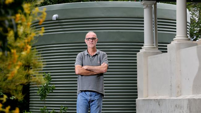 Magill resident Branko Soda with his neighbour’s rainwater tank. Picture: Sam Wundke/AAP