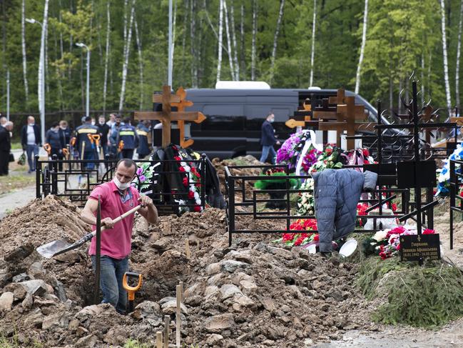 A grave digger prepares a grave in the section of a cemetery reserved for coronavirus victims, outside Moscow. Picture: AP