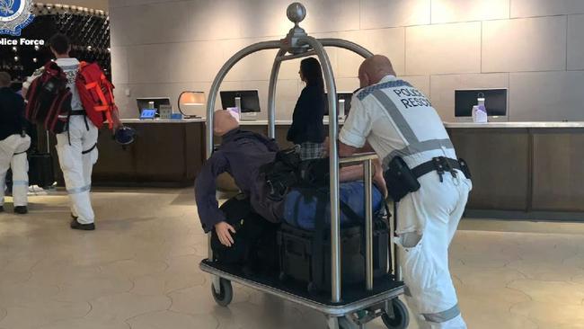 Police carry a dummy through the lobby of the Hyatt Regency on Sussex St.