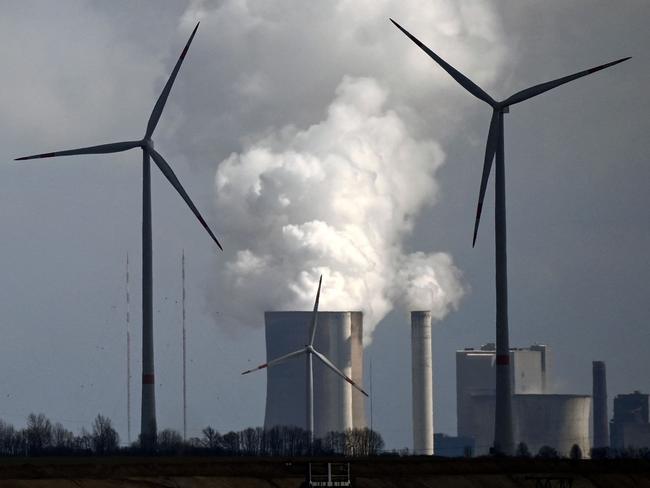 Wind turbines are seen near the coal-fired power station Neurath of German energy giant RWE in Garzweiler, western Germany, on March 15, 2021. - On March 16, 2021, the group will present its detailed figures for 2020, for the last time with RWE CEO Rolf Martin Schmitz. Despite the coronavirus pandemic, 2020 was a successful year for RWE. (Photo by Ina FASSBENDER / AFP)