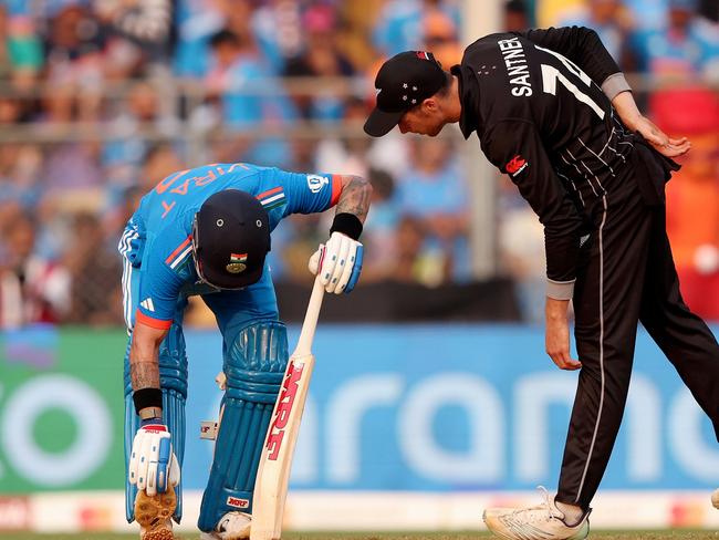 MUMBAI, INDIA - NOVEMBER 15: Virat Kohli of India stretches as Mitchell Santner of New Zealand looks on during the ICC Men's Cricket World Cup India 2023 Semi Final match between India and New Zealand at Wankhede Stadium on November 15, 2023 in Mumbai, India. (Photo by Robert Cianflone/Getty Images)