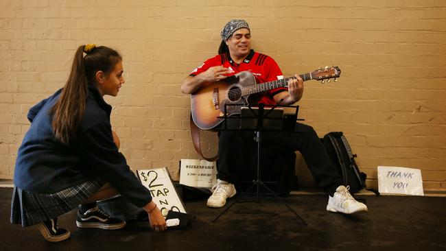 Tap n Go busker Joseph Jayde Trueman performing at Stanmore train station. Tyriesha Williams is tapping $2 with a credit card. Picture: Rohan Kelly.