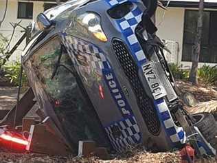 A police officer suffered a head injury when his patrol car rolled at a Black Mountain roundabout on Sunday. Photo: Facebook