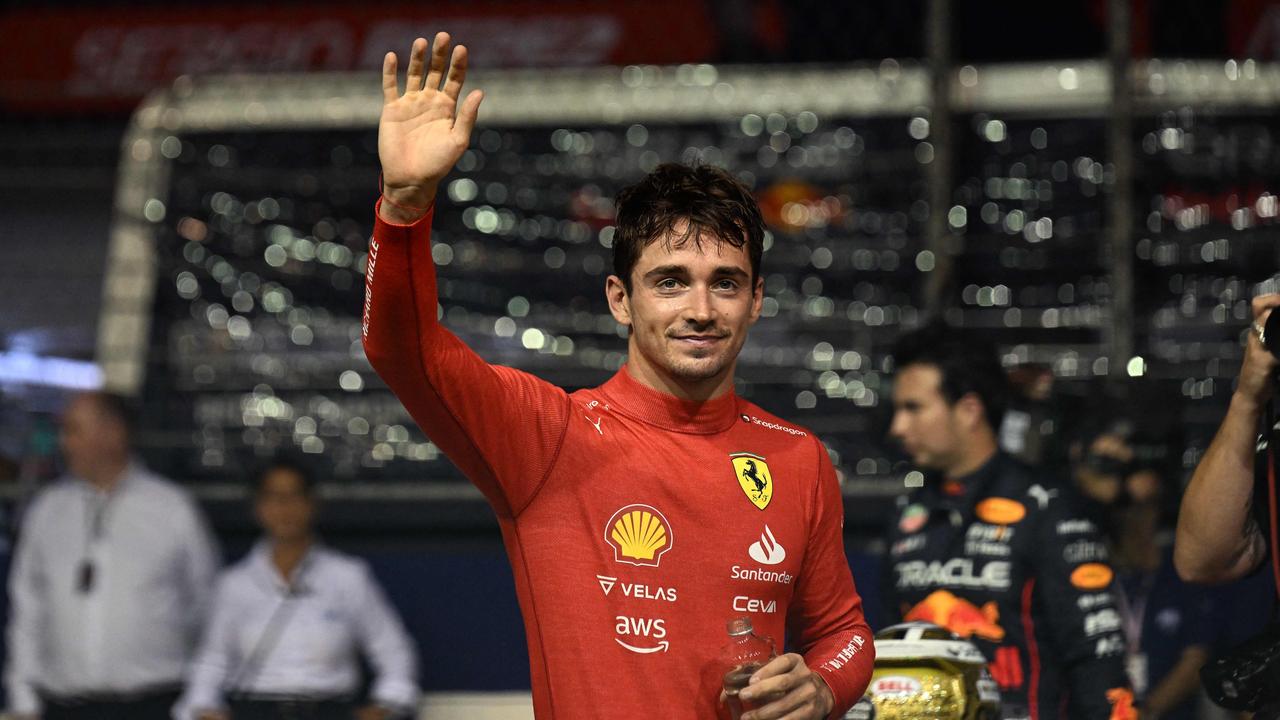 Charles Leclerc waves after taking the pole position. (Photo by Lillian SUWANRUMPHA / AFP)