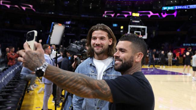 Patrick Carrigan and Adam Reynolds take a courtside selfie.