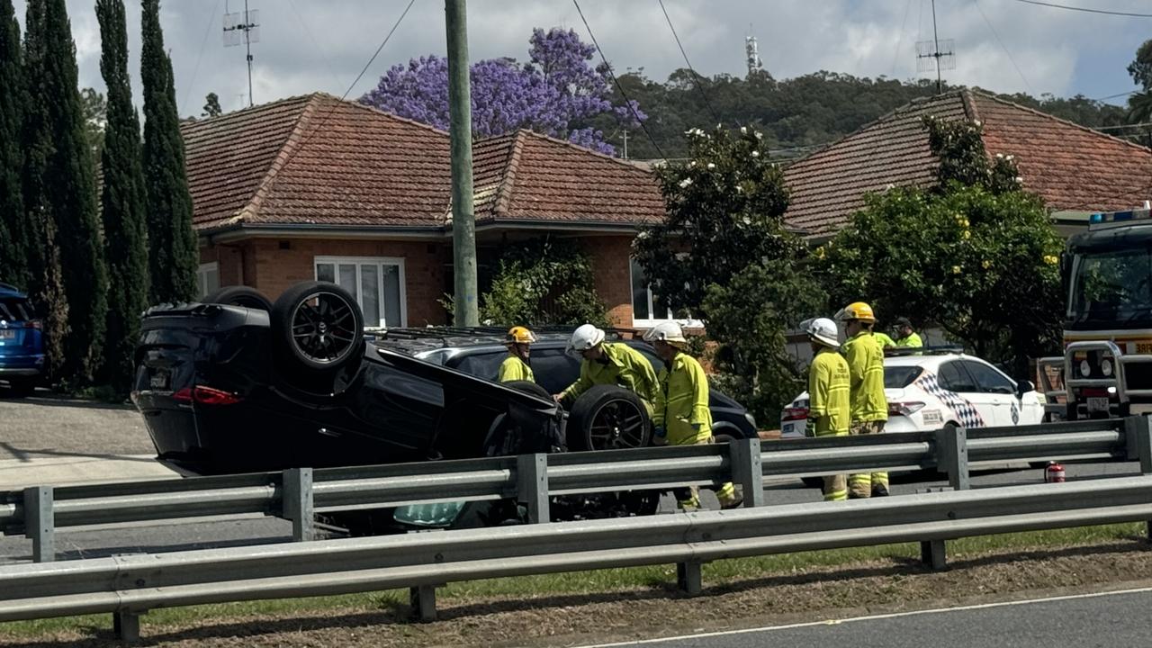 Person trapped as car flips onto roof in Brisbane crash