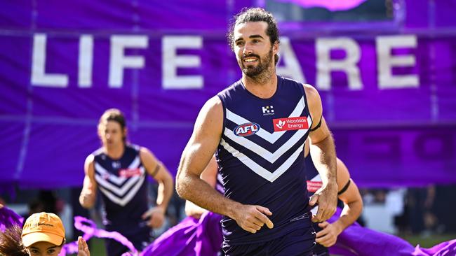 PERTH, AUSTRALIA - MARCH 17: Alex Pearce of the Dockers leads the team through the banner during the 2024 AFL Round 01 match between the Fremantle Dockers and the Brisbane Lions at Optus Stadium on March 17, 2024 in Perth, Australia. (Photo by Daniel Carson/AFL Photos via Getty Images)