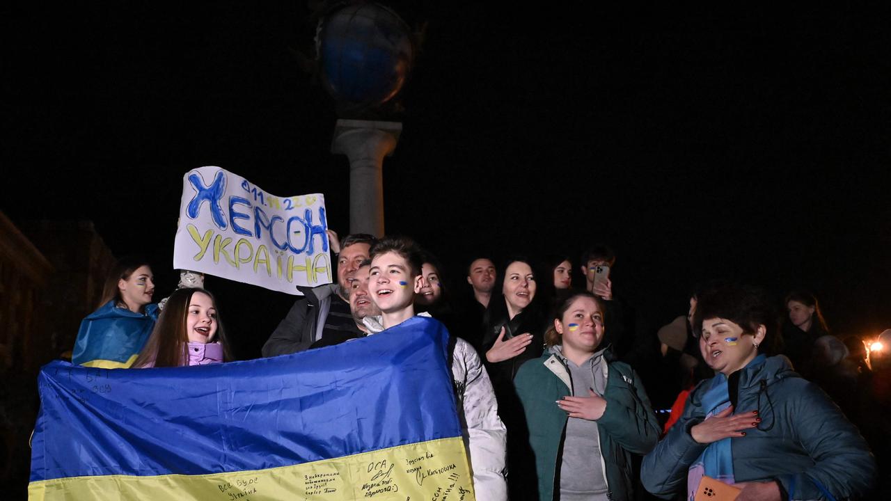 People hold a Ukrainian flag and a slogan which reads ‘Kherson – Ukraine’. Picture: Genya Savilov/AFP