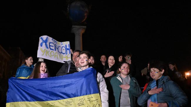 People hold a Ukrainian flag and a slogan which reads ‘Kherson – Ukraine’. Picture: Genya Savilov/AFP