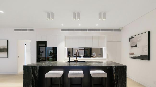 The chefs kitchen at 109 Anthony Street, Ascot with a leather-finished Italian granite waterfall-edge kitchen island in Cambrian Black comes with Miele appliances and Zip HydroTap.