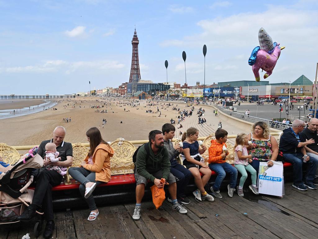 People relax on benches on the Central Pier in Blackpool. England has abandoned the idea of using health passports, for now. Picture: AFP