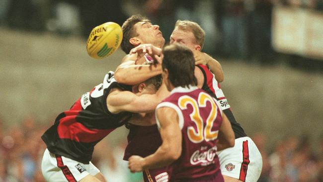 Lynchy gets swallowed up by Damien Hardwick and Dean Wallis in a tackle during the 1996 qualifying final at the Gabba.