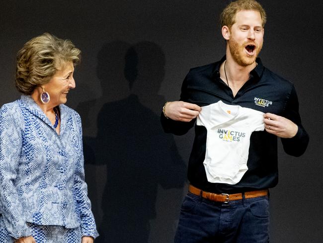 Prince Harry, right, with the adorable onesie for his newborn son Archie, as gifted by Princess Margriet of the Netherlands. Picture: Getty Images 