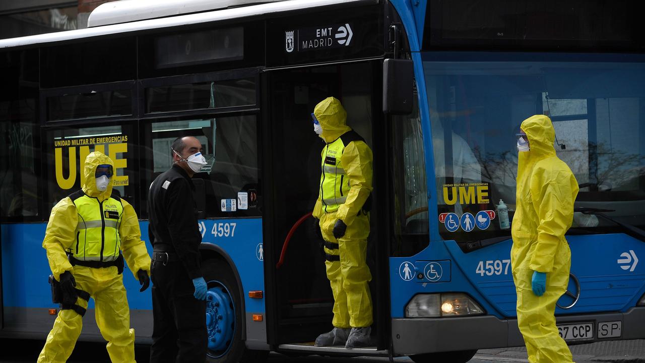 Members of the Spanish military dressed in hazmat suits assist patients on buses to a temporary hospital on Sunday. Picture: Pierre-Philippe Marcou/AFP