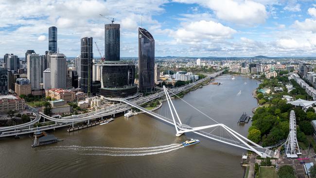 Developing Queensland - Discover the dramatic aerial view of the financial district skyscrapers and Brisbane River in Queensland, Brisbane, Australia, during summer. The stunning skyline and winding river create a picturesque urban landscape perfect for business and leisure.