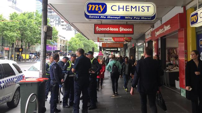 Police outside My Chemist on Elizabeth St after a man was seen on the roof of the shop. Picture: Andrea Hamblin.